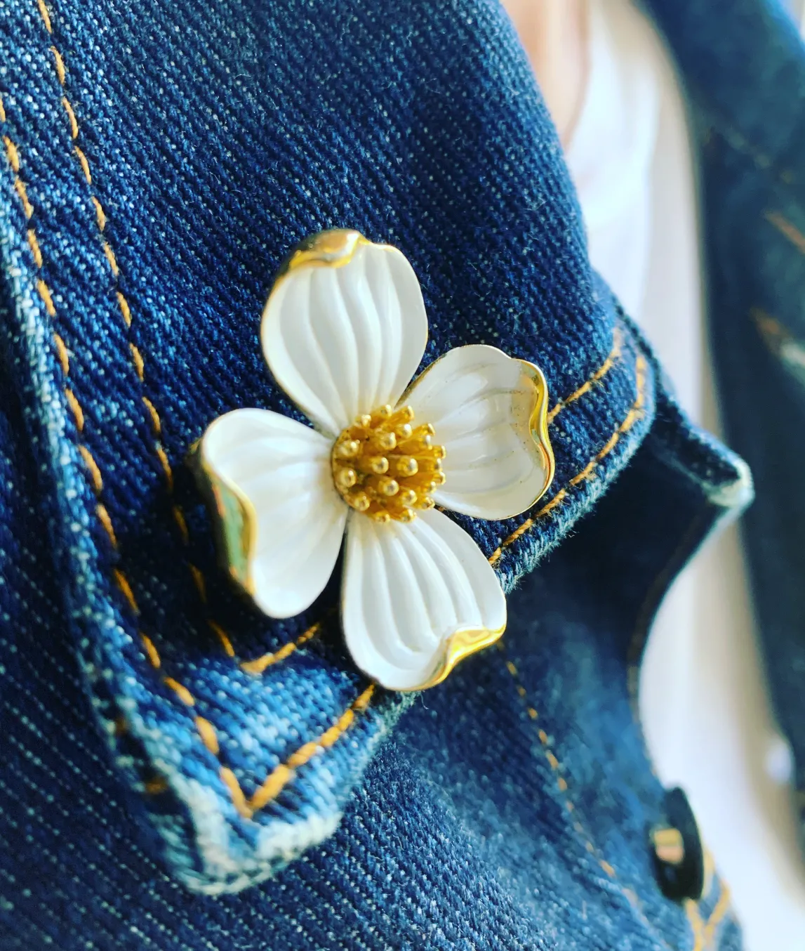 White trifari dogwood brooch on denim