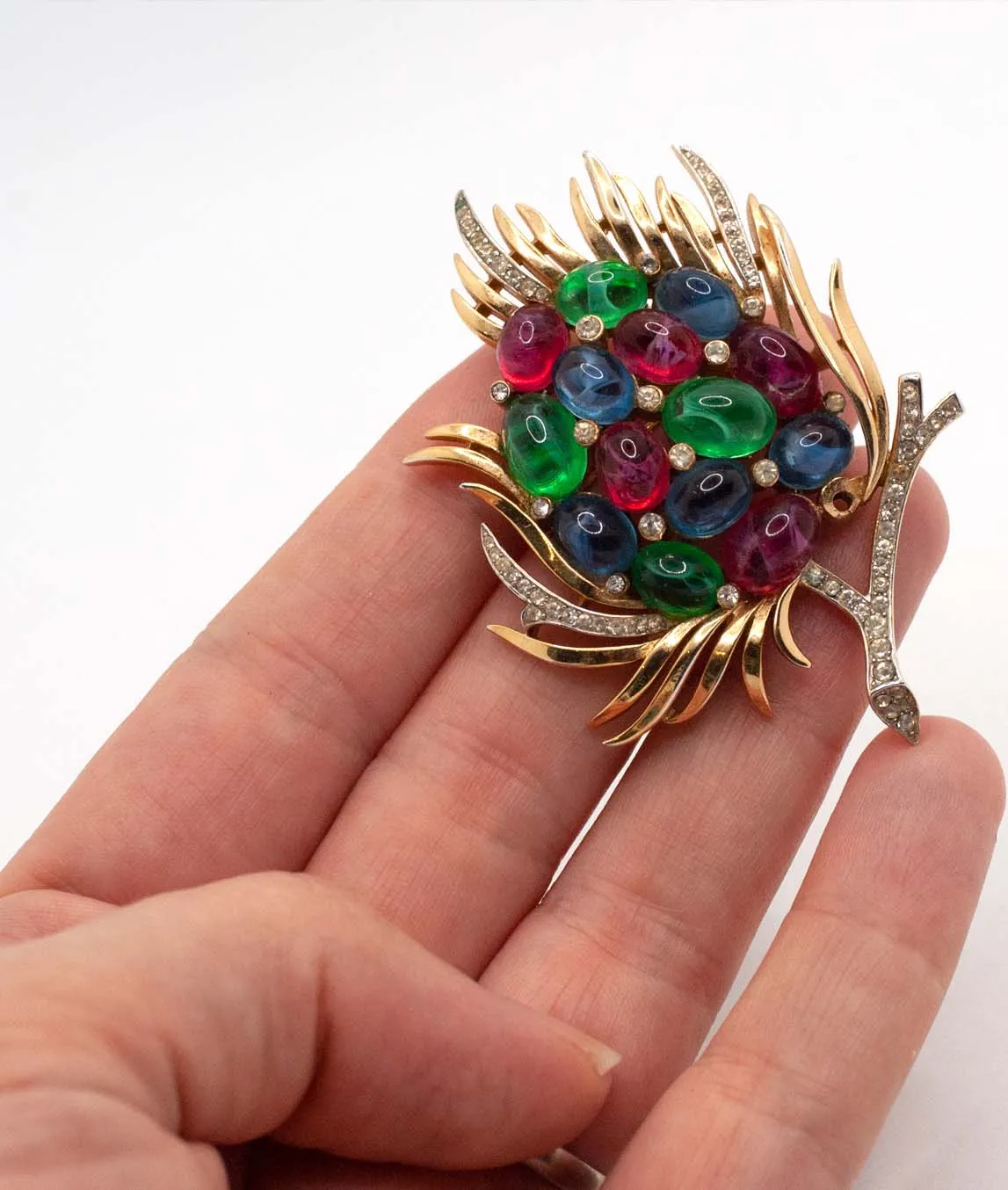 Trifari Jewels of India brooch red blue green and gold held in hand