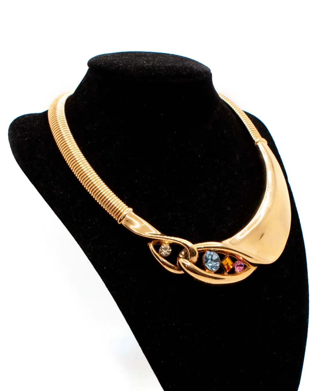 Givenchy gold tone crystal decorated collar necklace top view on a black display