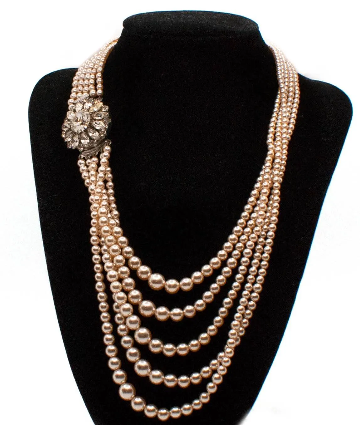 Vintage multi-strand faux pearl champagne coloured necklace with decorative clasp on a stand
