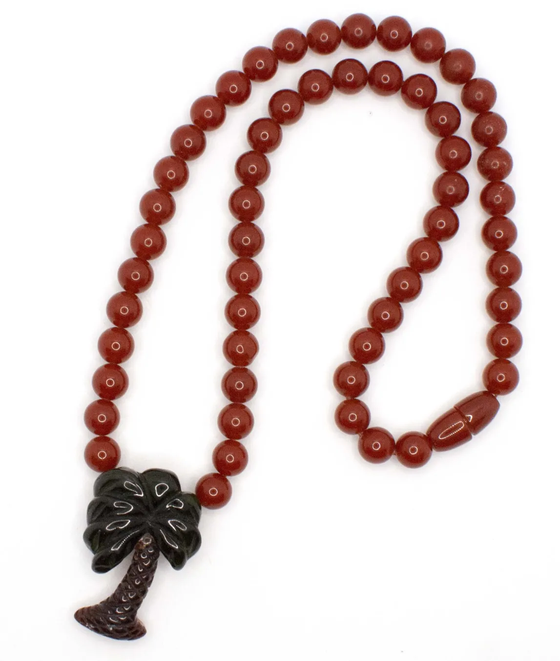 Reddish brown plastic beaded necklace with carved palm tree pendant 