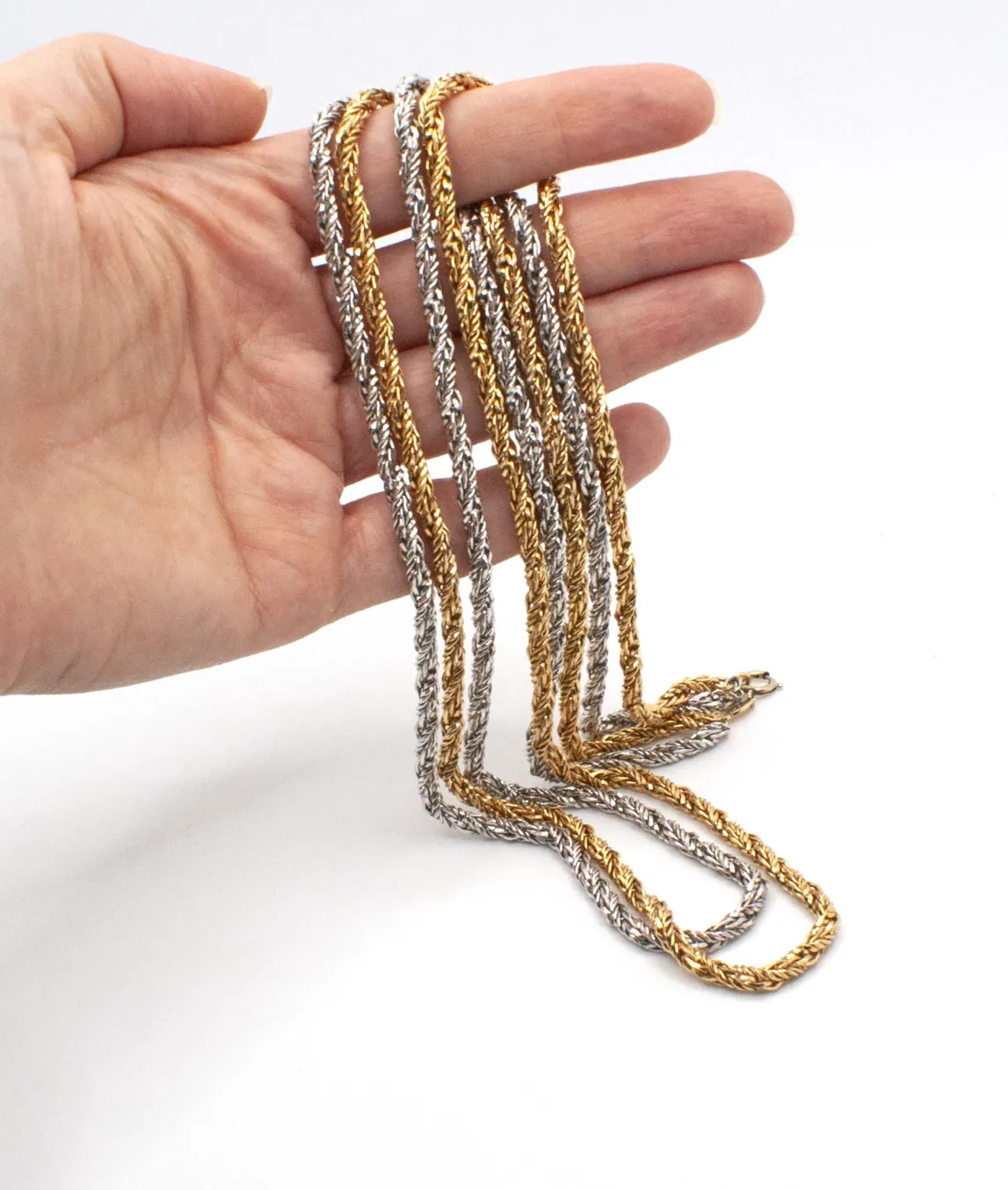 Two strand long rope chain in silver and gold by Grossé held in hand
