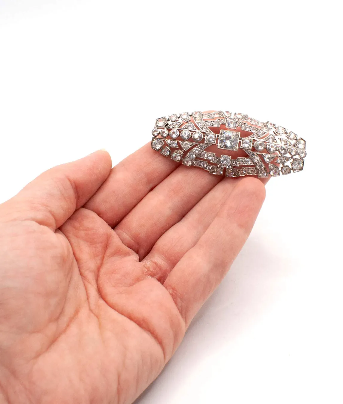 1930s silver and zircon brooch held in a hand