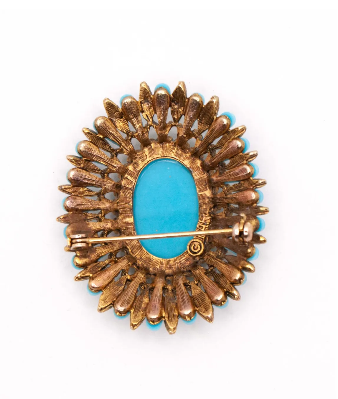 Reverse of oval shaped turquoise glass brooch by HAR with roll clasp