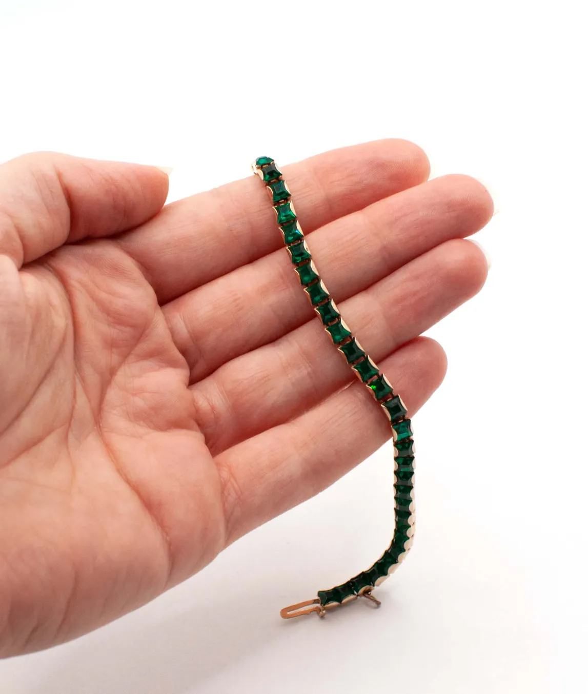 Green Weiss tennis bracelet held in a hand