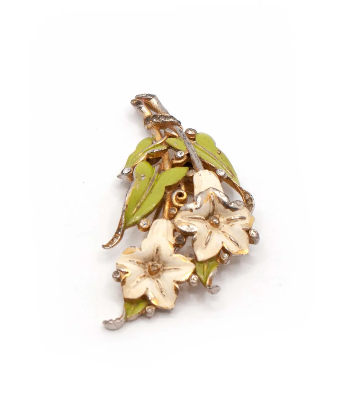 Top side view of enamel brooch with green leaves and two ivory flowers