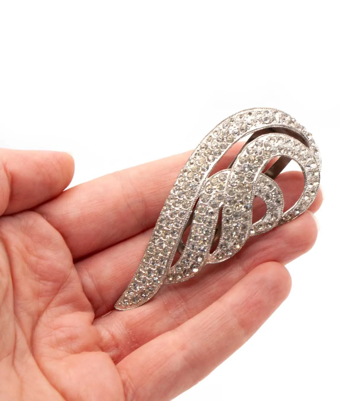 Wing shaped crystal dress clip held in hand