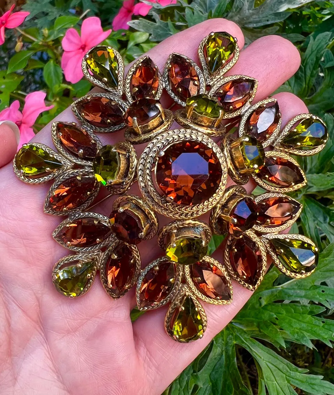 Large layered brooch by Christian Dior with brown amber and green crystals set in gold plated metal