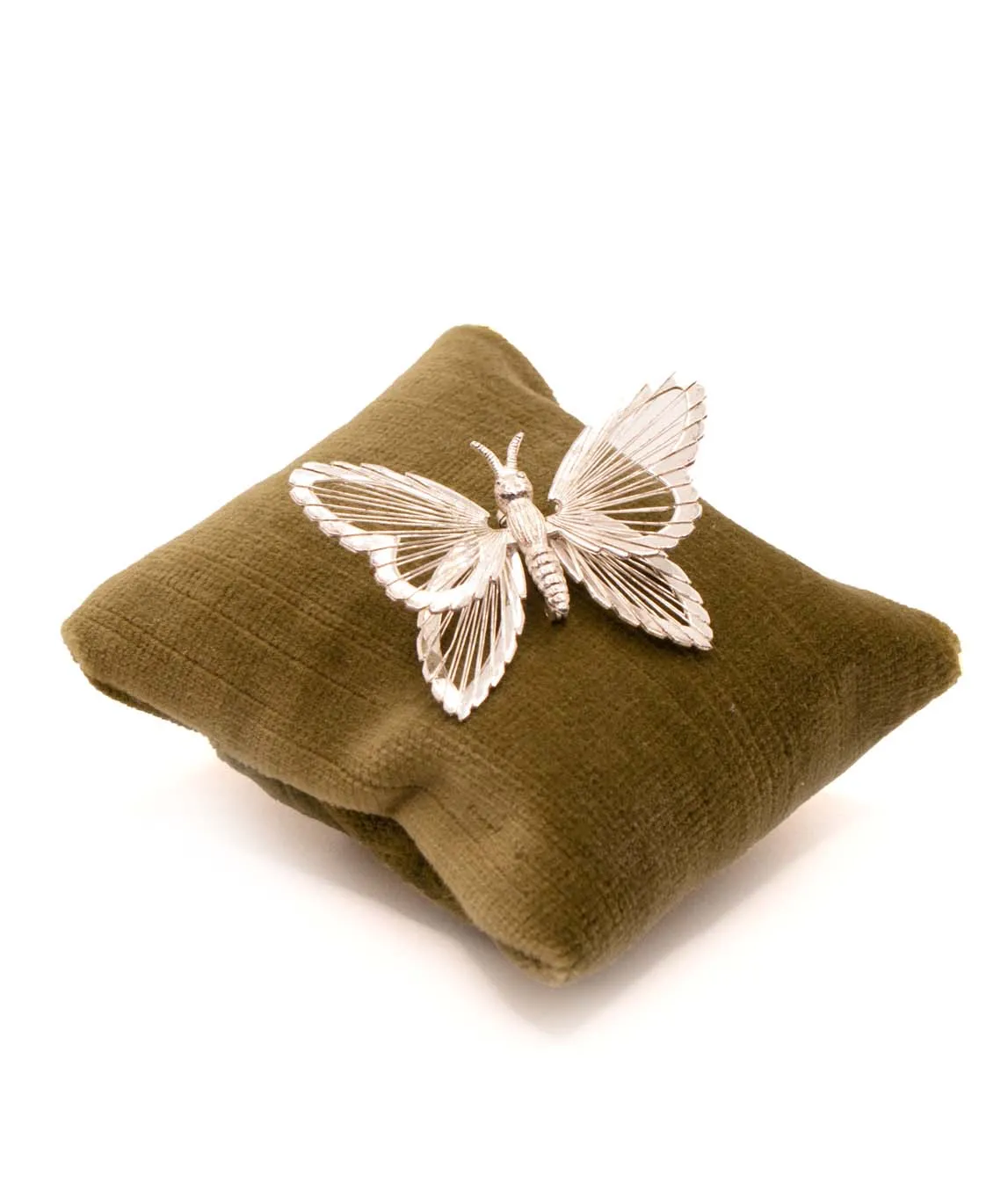 Monet silver tone wire butterfly brooch sitting on green velvet pillow