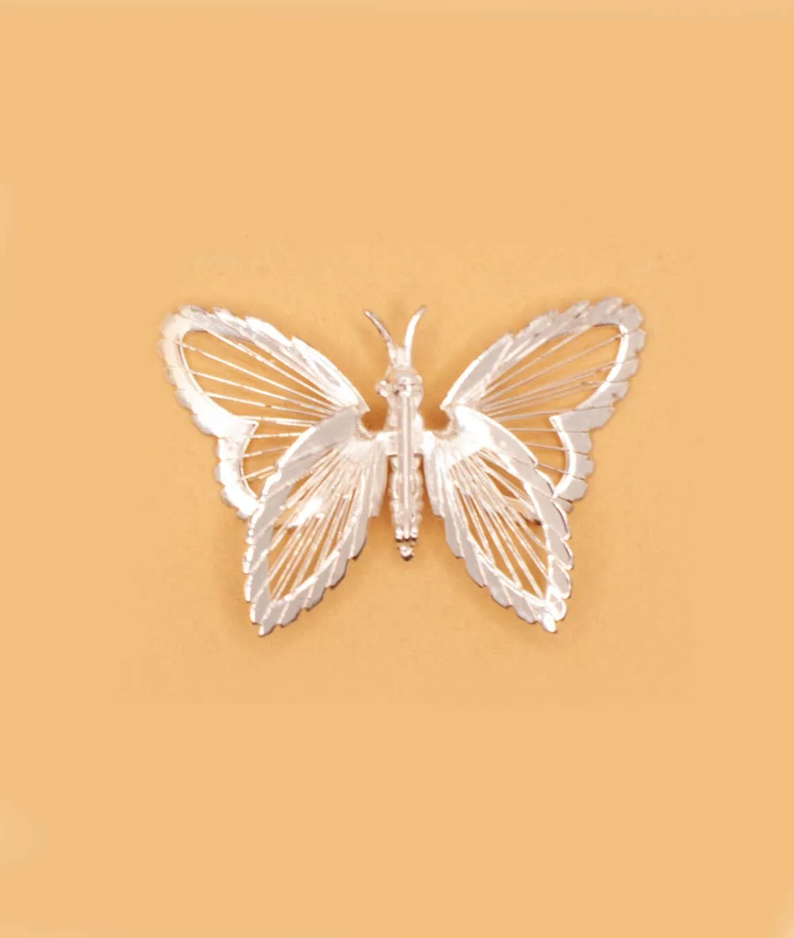 Monet silver tone wire butterfly brooch back view on beige background