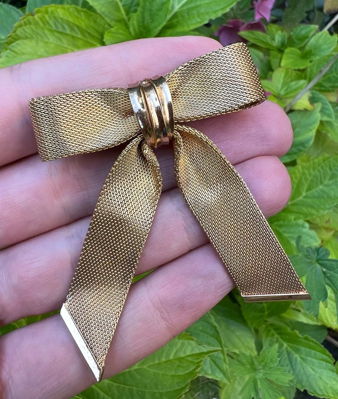 Christian Dior 1964 gold plated woven metal bow brooch with garden background