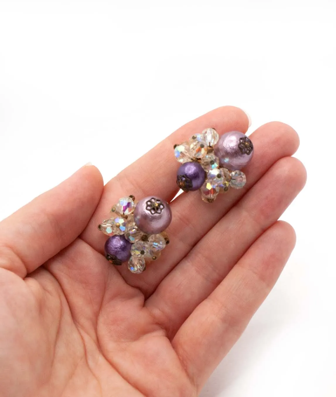 Vendôme purple bead and clear crystal cluster earrings held in a hand