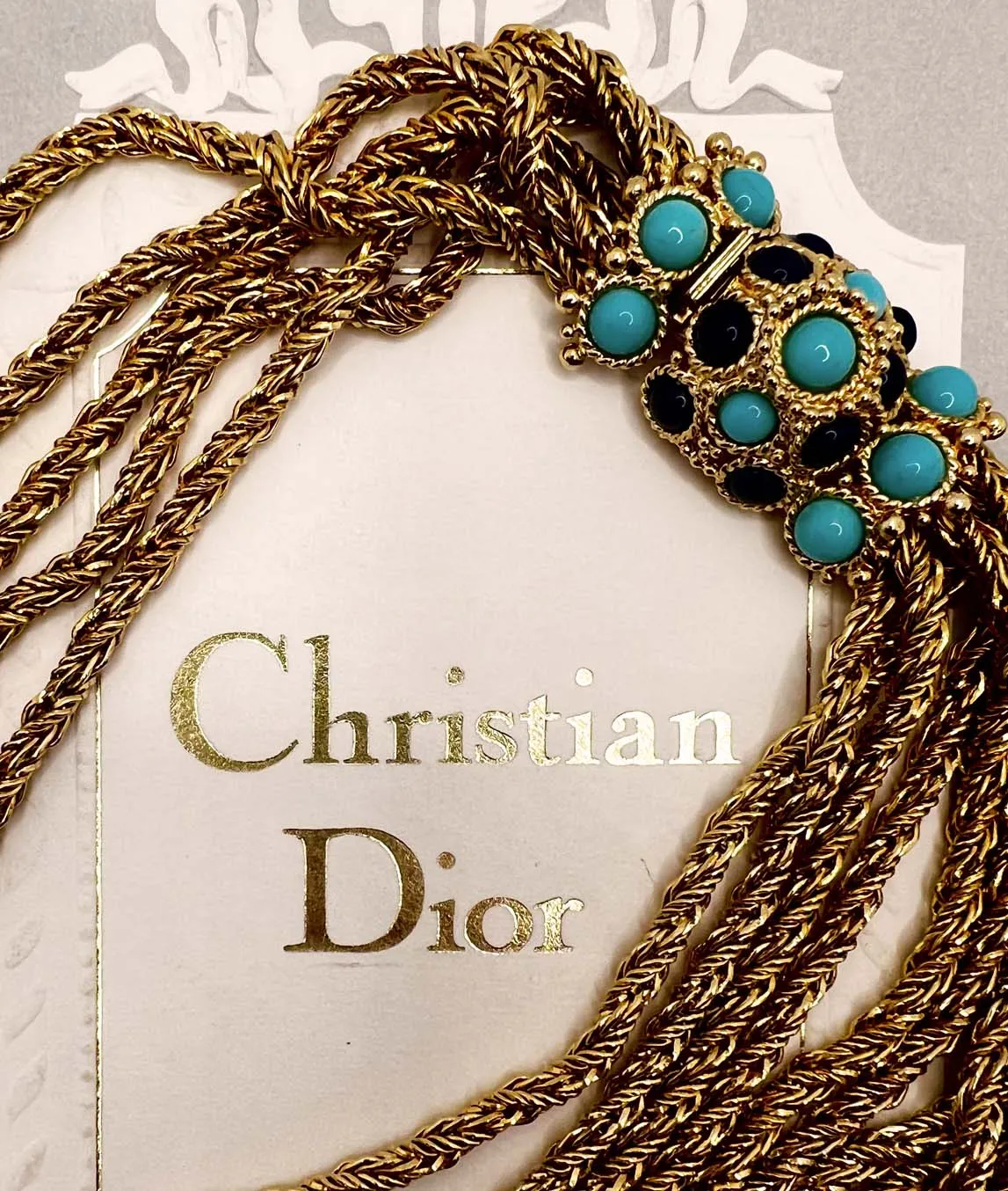Christian Dior chain necklace with turquoise and blue glass decorative clasp on Christian Dior box