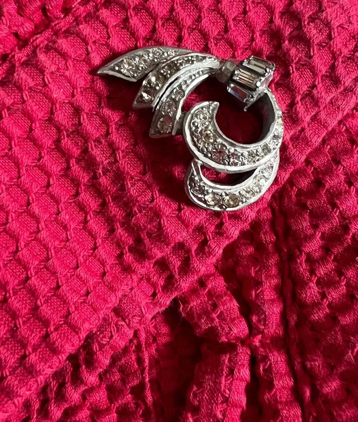 Art Deco dress clip worn on a pink jacket cuff