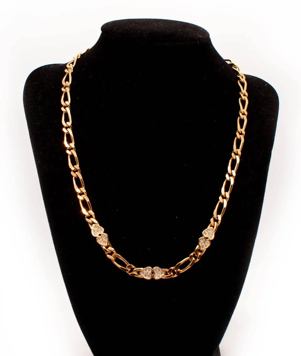 Fancy link gold tone chain necklace by Grosse with crystal hearts on black display bust