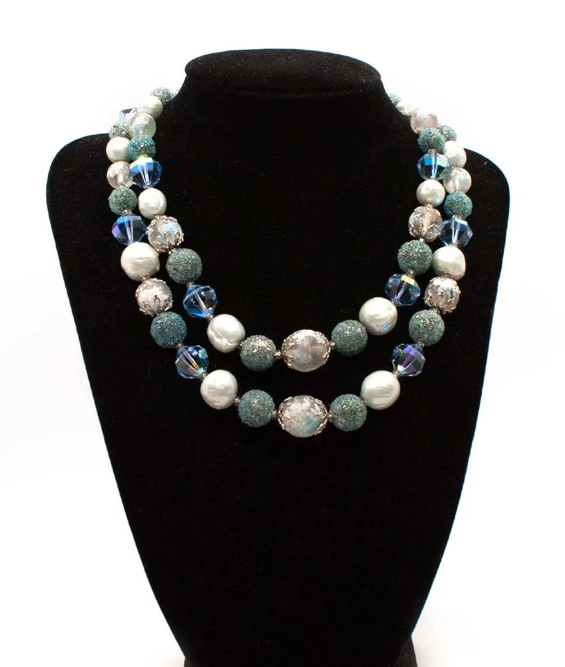 Vendôme Necklace blue green and white beads on a black display bust