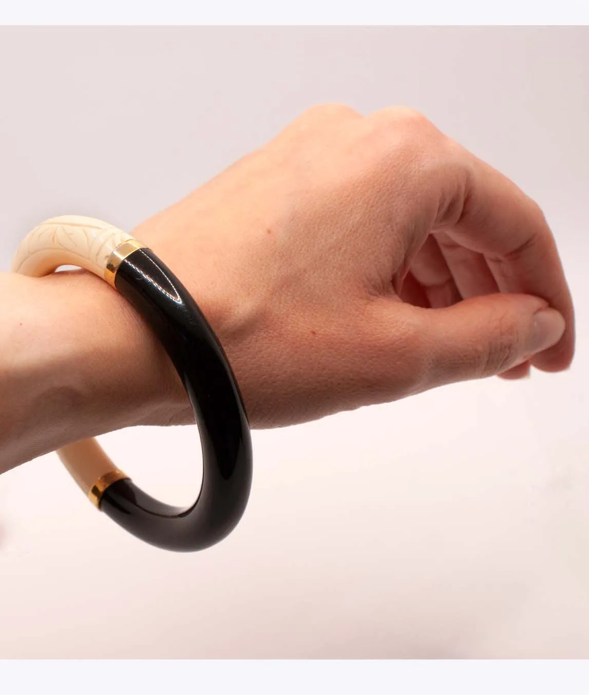 Givenchy black and ivory plastic bangle bracelet on a wrist