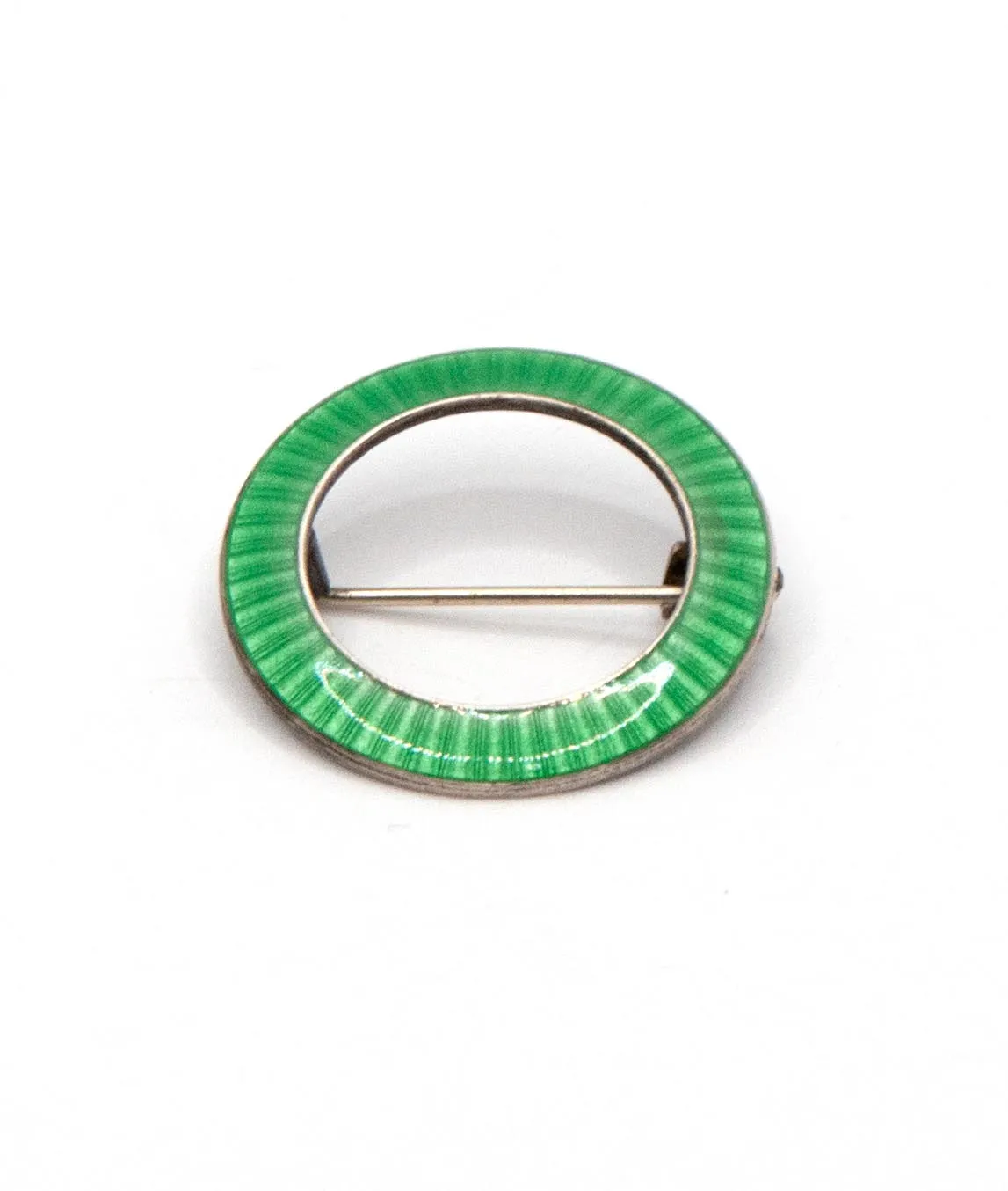 JA&S green enamelled ring shaped brooch pin set in silver on a white background tilted at an angle