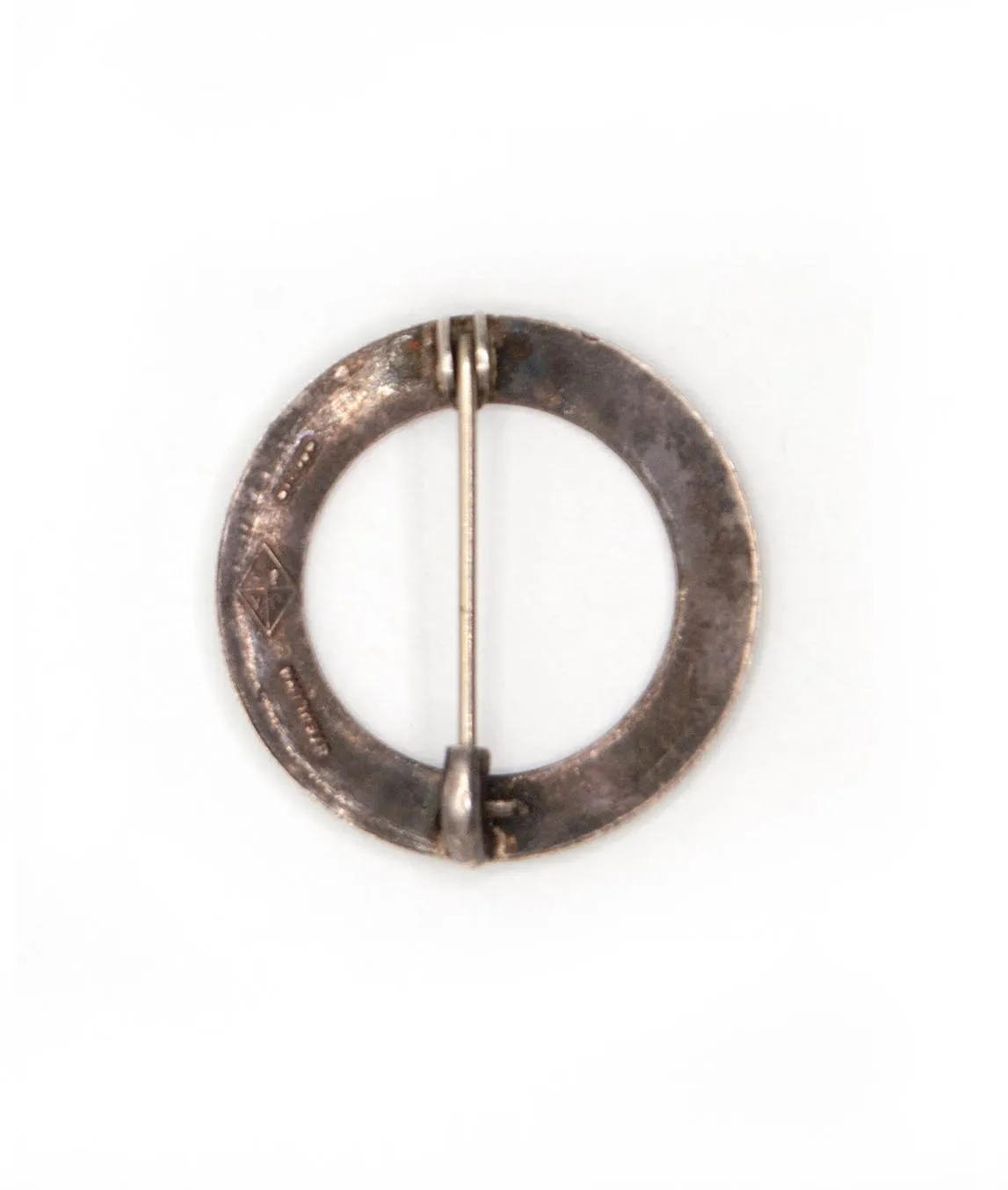 Back of circular silver brooch with tarnish