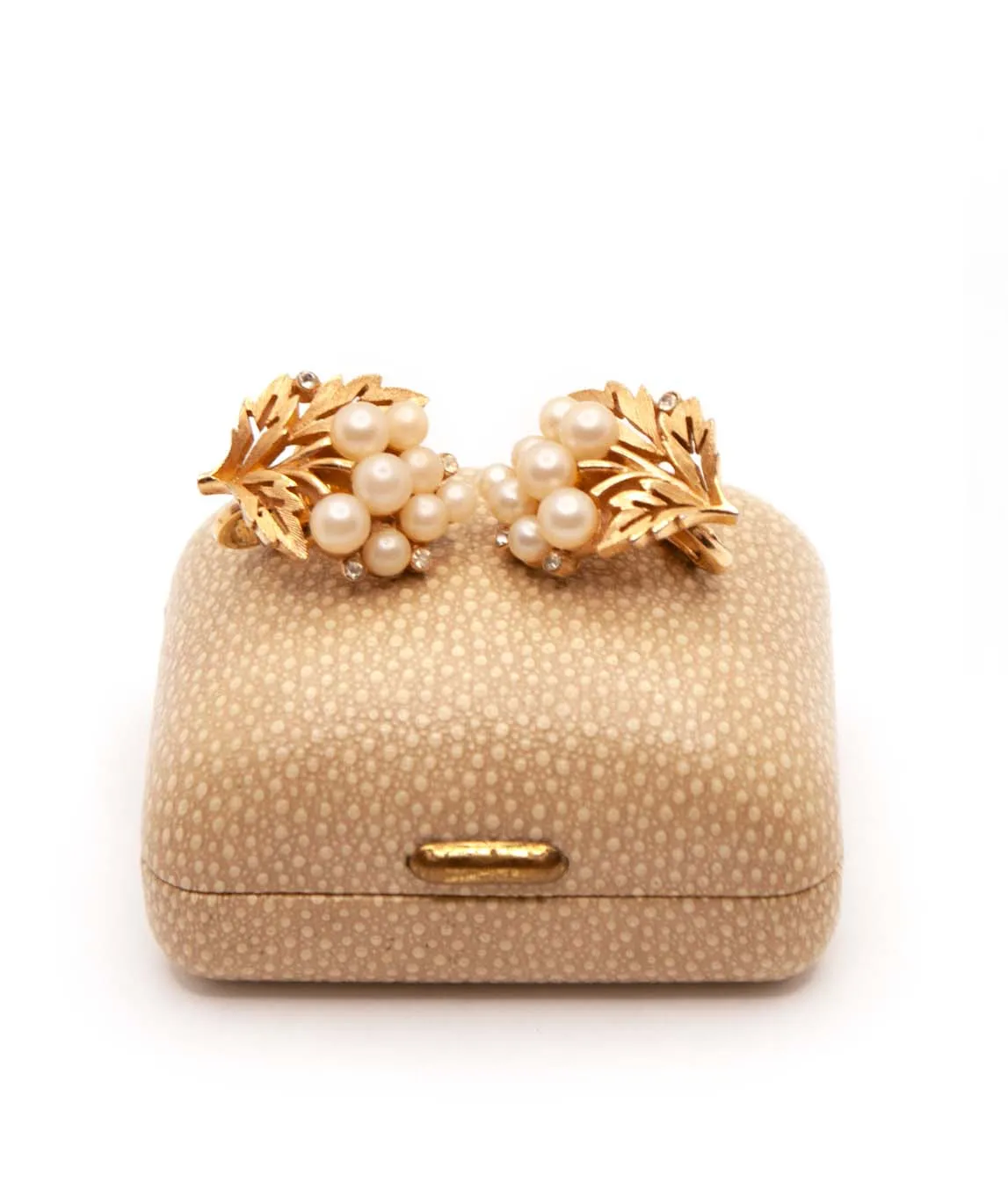 Crown Trifari textured gold plated earrings with faux pearls and rhinestones on a beige shagreen box