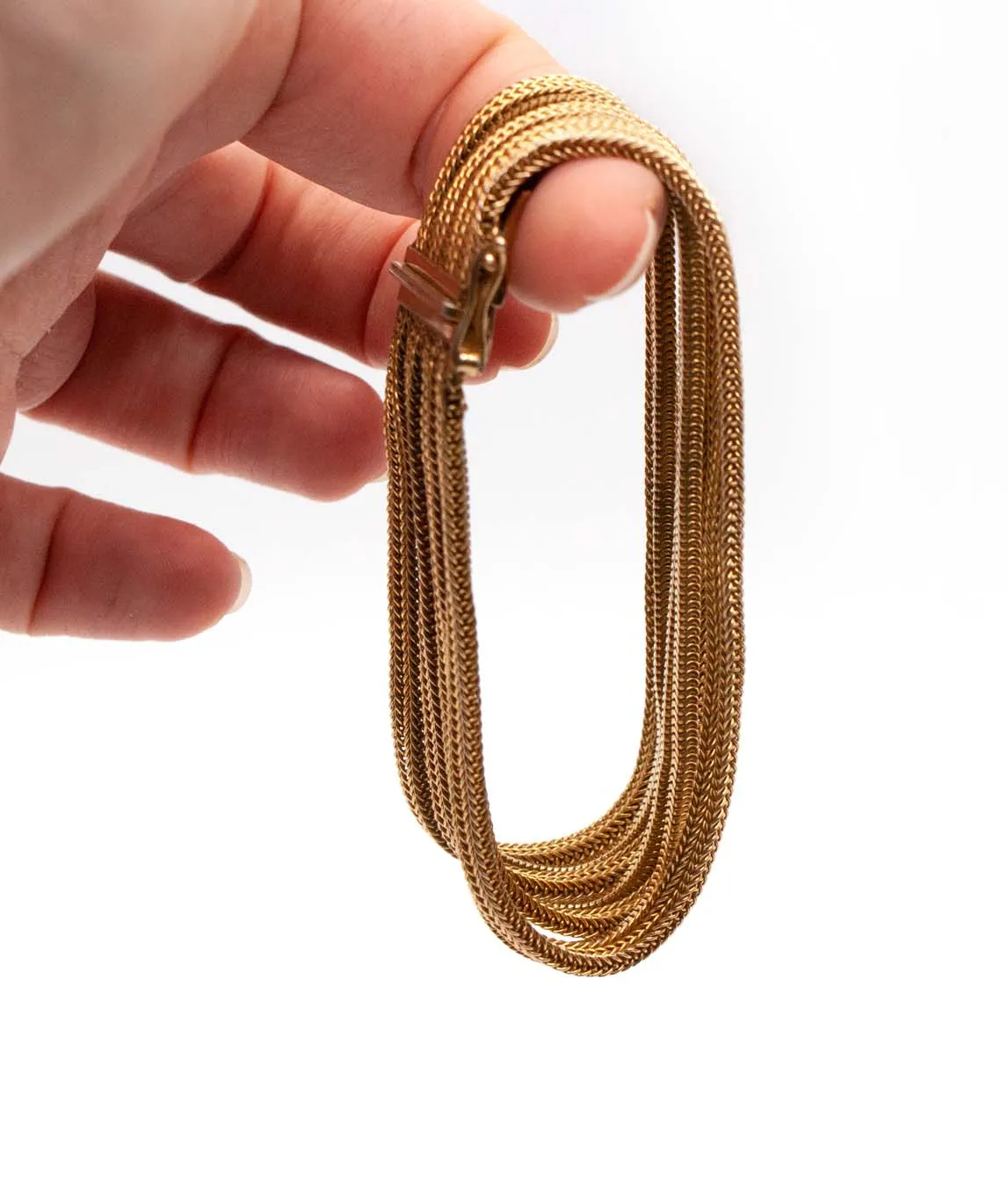 Grosse multi-chain woven gold plated bracelet held on finger