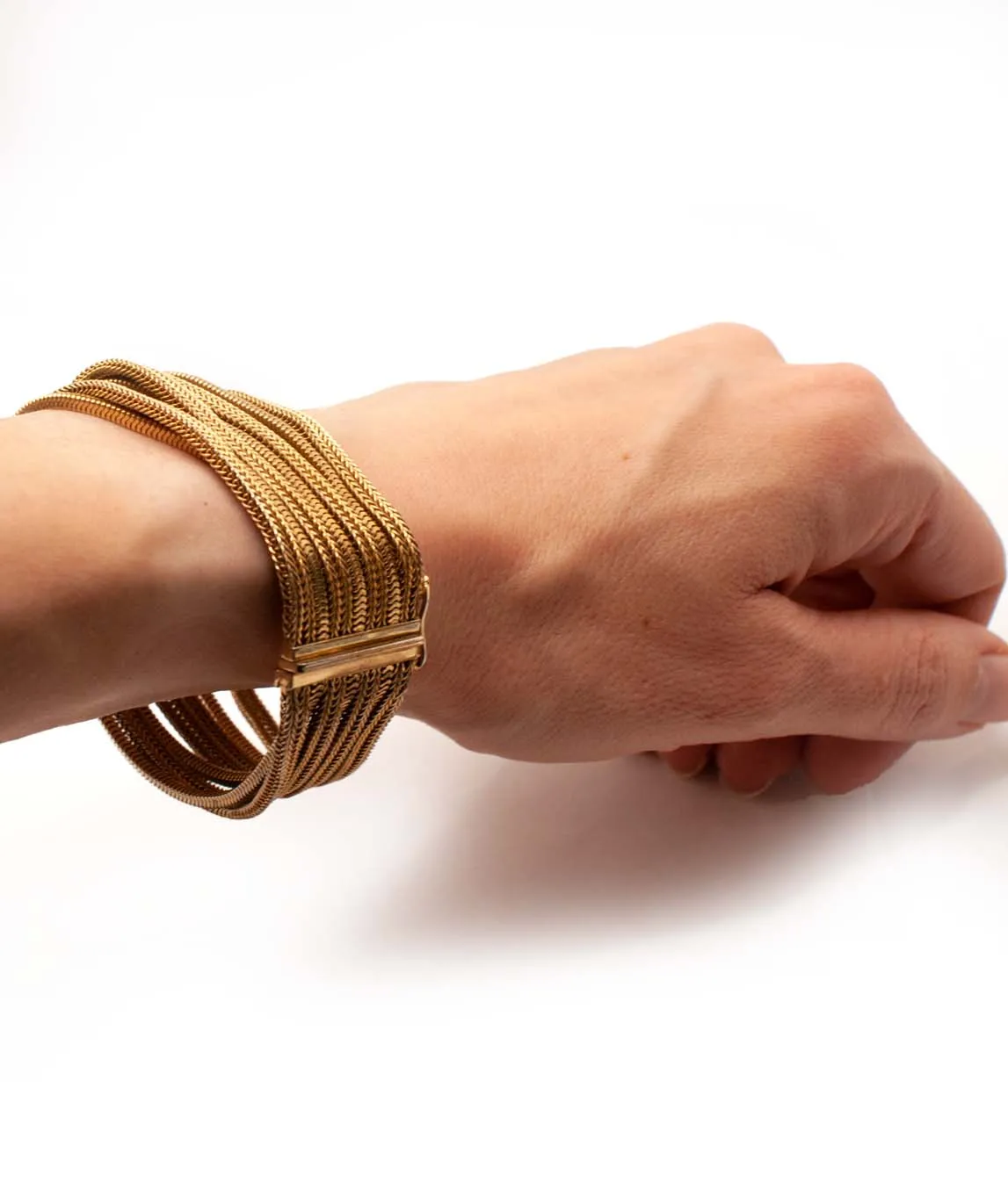 Grosse multi-chain woven gold plated bracelet worn on wrist