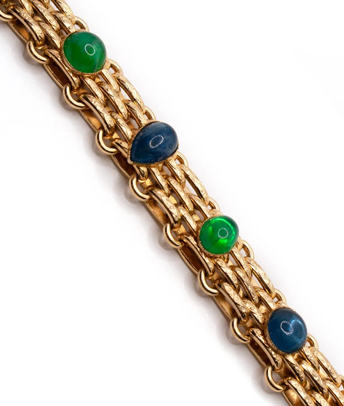 Top view of green and blue poured glass gems on gold link bracelet by Christian Dior