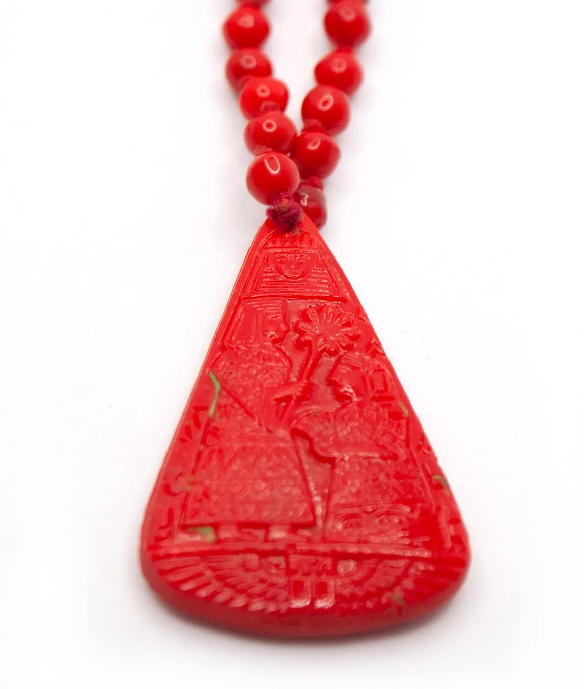 Large red pendant in pear-shape with remnants of green paint on Neiger brothers necklace at slight angle
