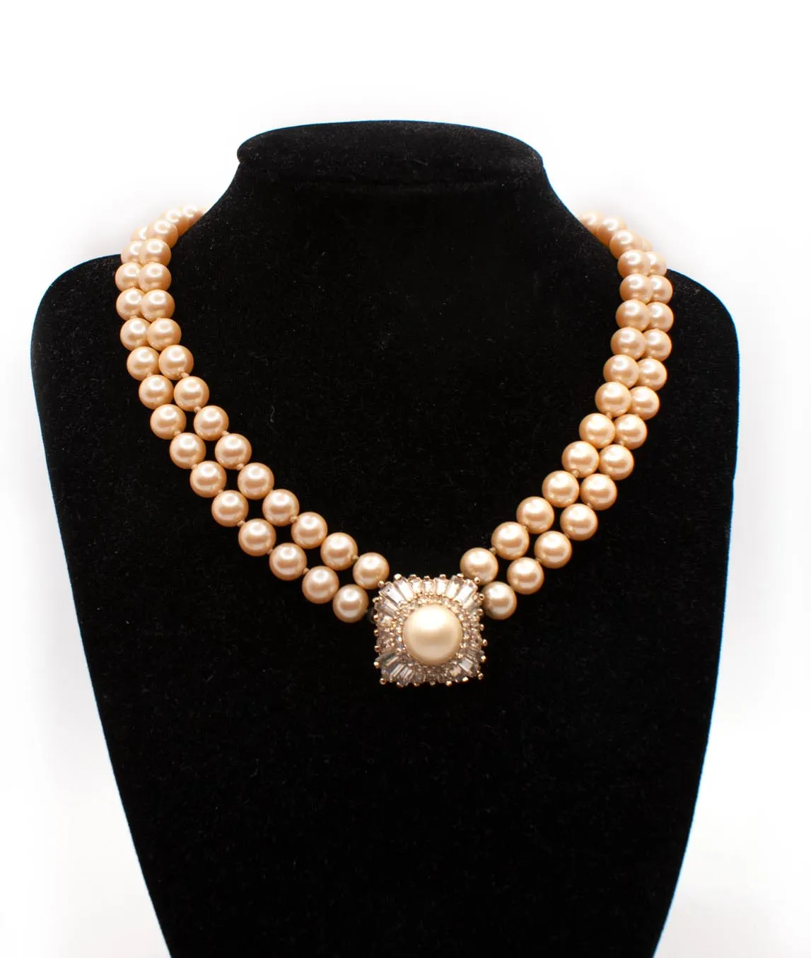 Champagne faux pearl necklace by Panetta on a black display bust