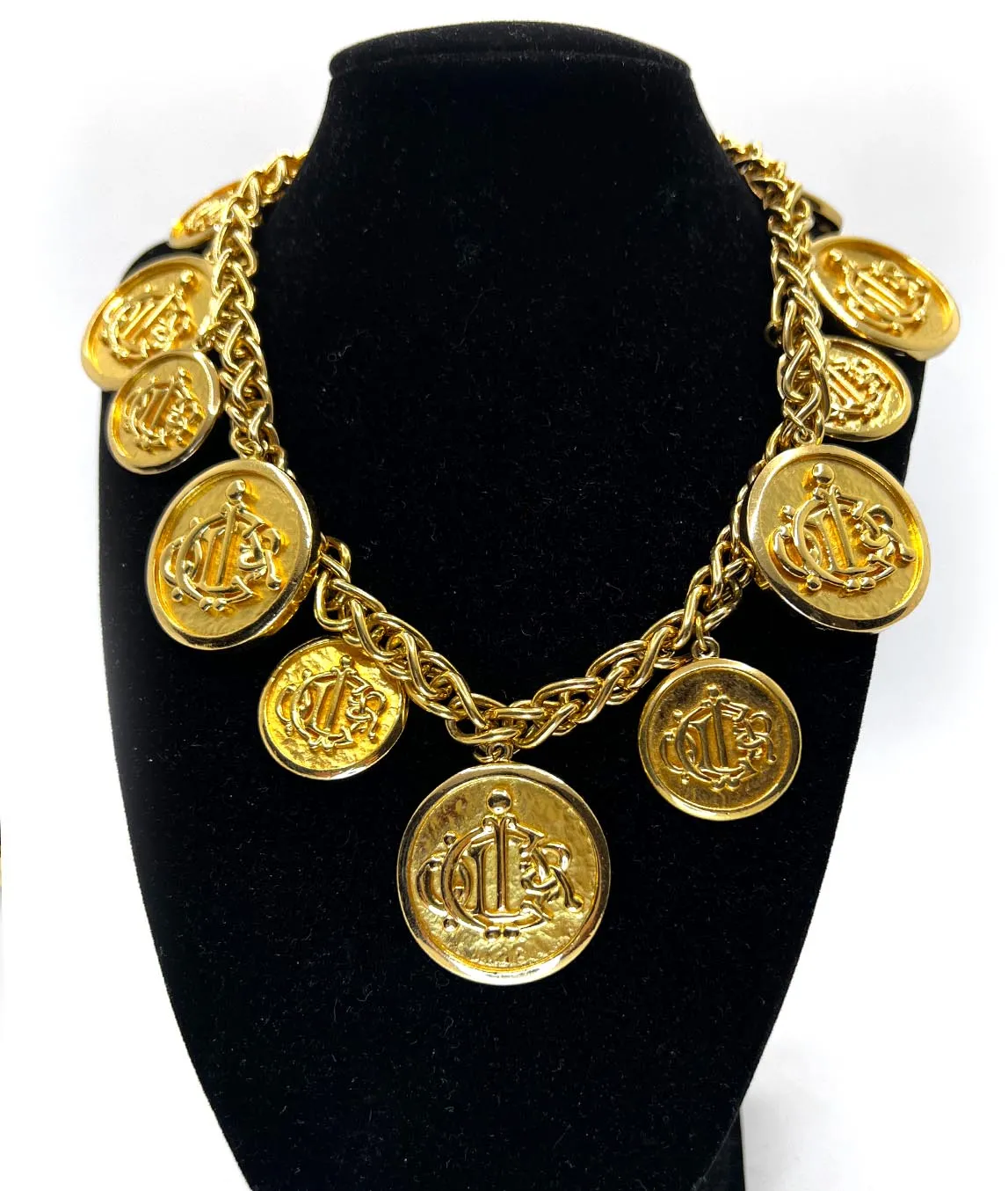 Gold plated heavy link chain with coin medallions showing Christian Dior logo on a black display