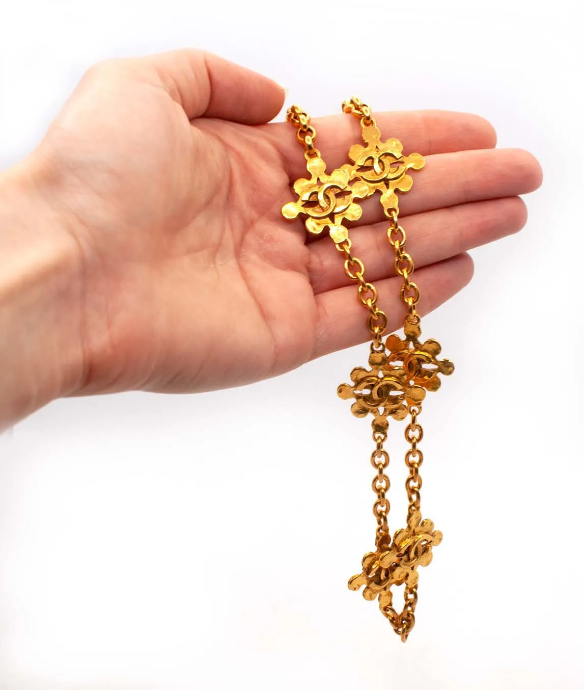 Chanel CC medallion chain necklace held in a hand