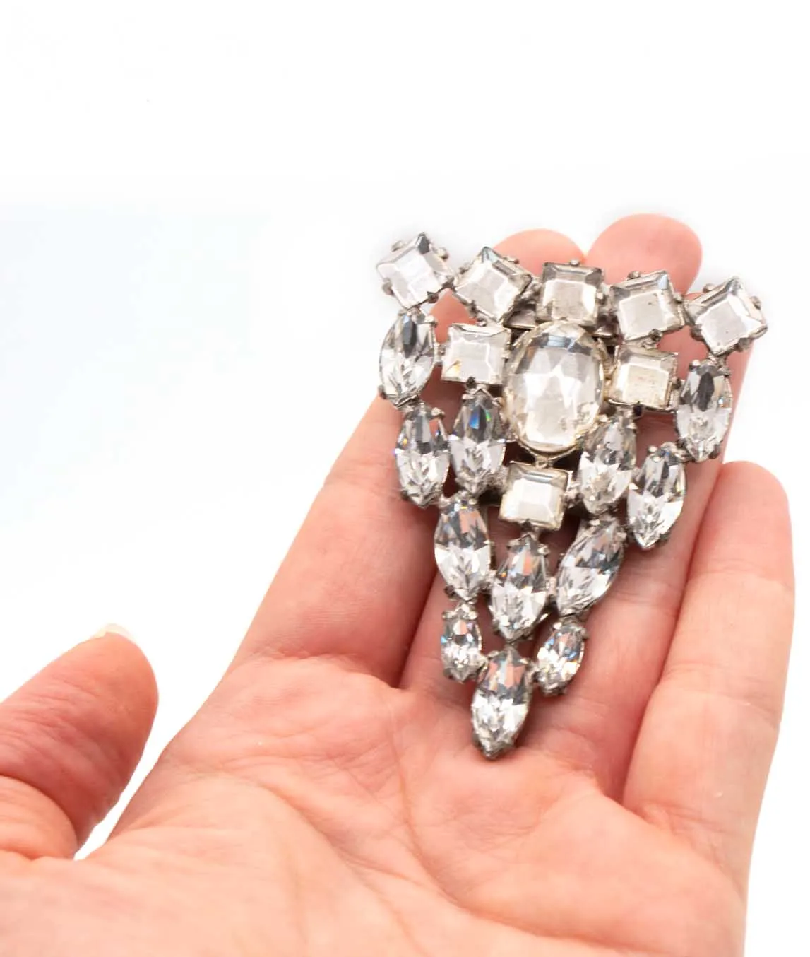 Large clear crystal dress clip held in a hand