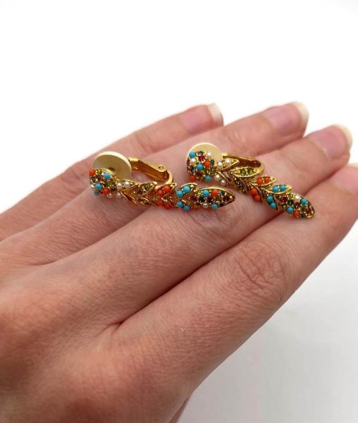 Small D'Orlan multicolour gold plated articulated earrings held in the hand