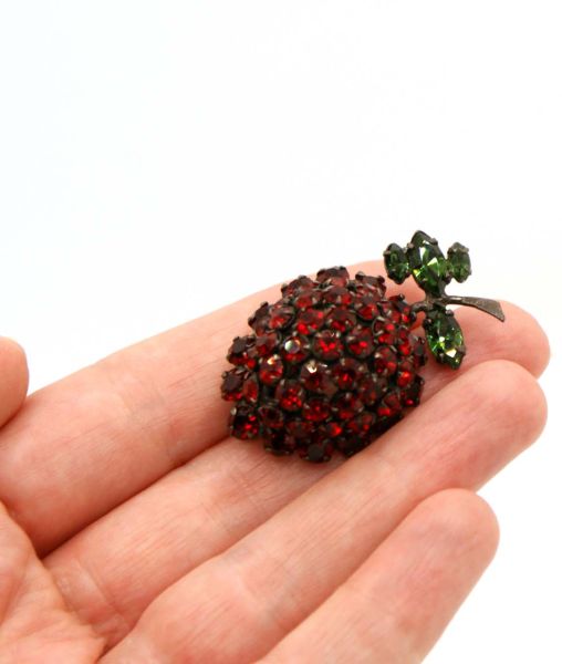 Schreiner red berry brooch held in the hand