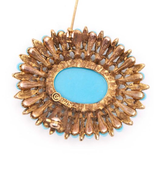 Reverse of turquoise glass brooch by HAR showing signature